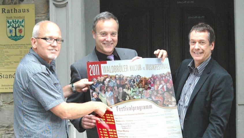 Eckhard Becker (Wir für Waldbröl GmbH), Peter Koester (Bürgermeister Stadt Waldbröl), Norbert Sell (Projektmanager) präsentieren das Plakat zum diesjährigen Waldbröler Kultur- und Musikfestival