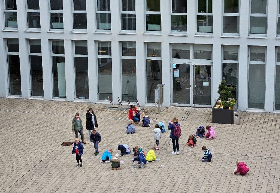 Kindergartengruppe des ev. Kindergartens Wassertropfen verschönert Innenhof des Rathauses
